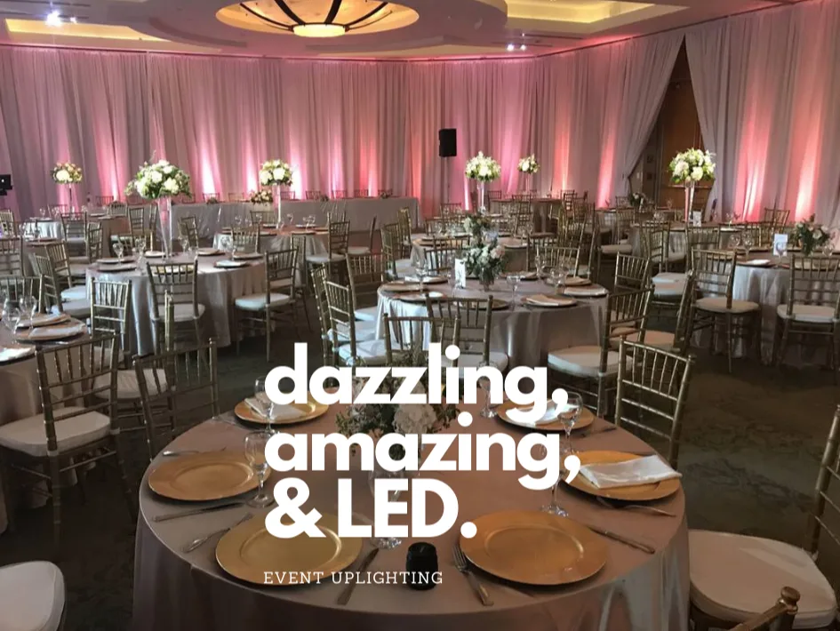 Elegant ballroom washed in soft pink LED uplighting with gold place settings at a Detroit event