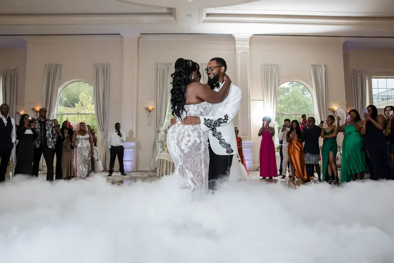 Couple sharing a first dance surrounded by low-lying cloud fog in an elegant ballroom