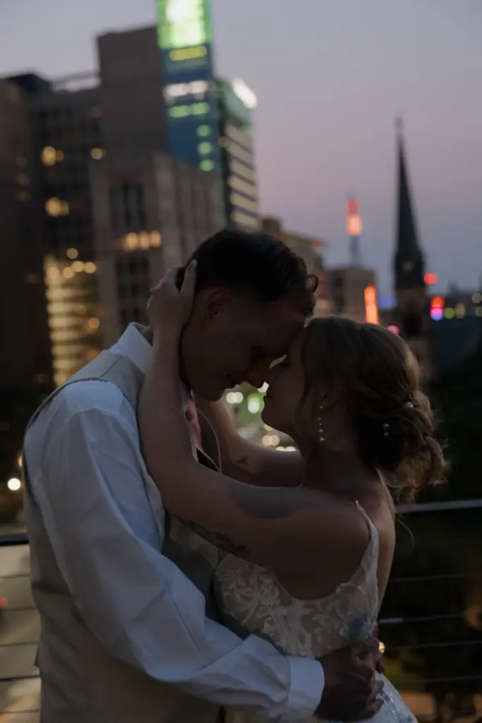 Bride and groom at dusk with the Detroit skyline behind them