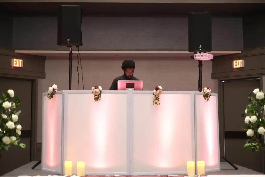 Skan the DJ wedding DJ booth with pink uplighting at a Detroit reception