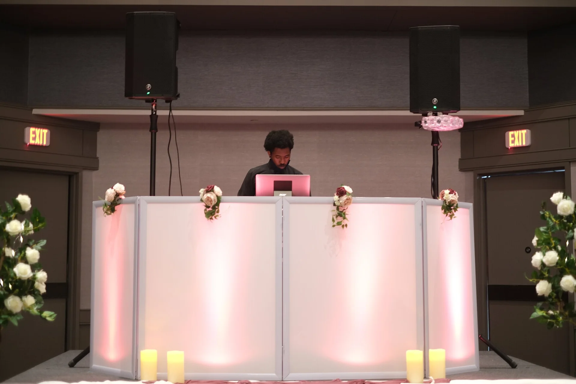 Skan the DJ wedding DJ booth glowing with pink uplighting at a Detroit reception