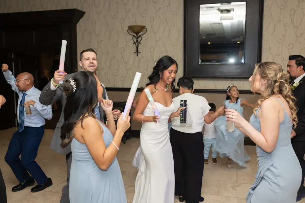Packed wedding dance floor glowing with light