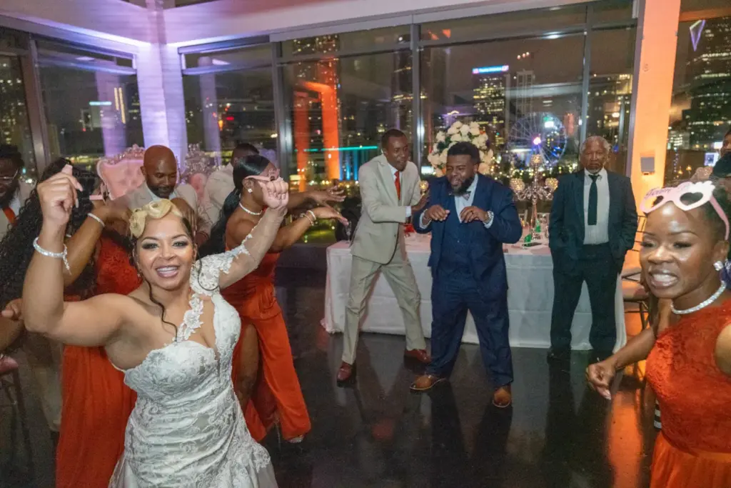 Packed wedding reception dance floor with colorful uplighting