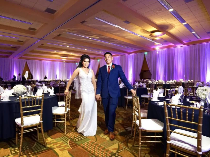 Couple in a ballroom washed with purple and pink uplighting at a Detroit reception