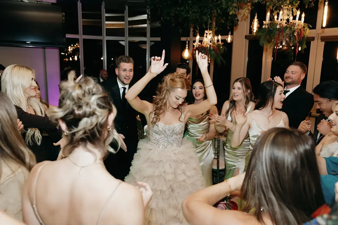 Guests dancing with their arms up at a wedding reception