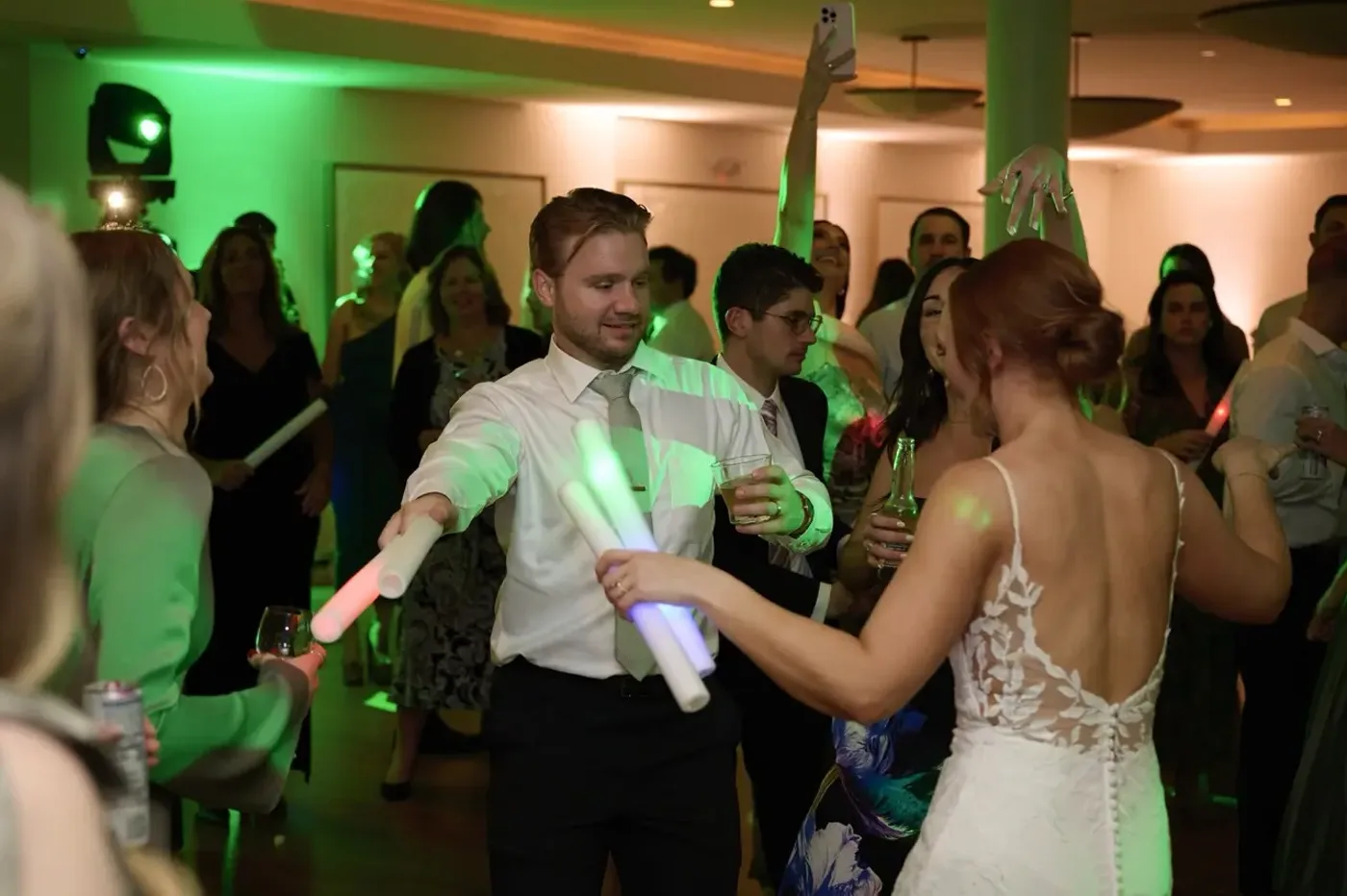 Guests dancing under green party lighting