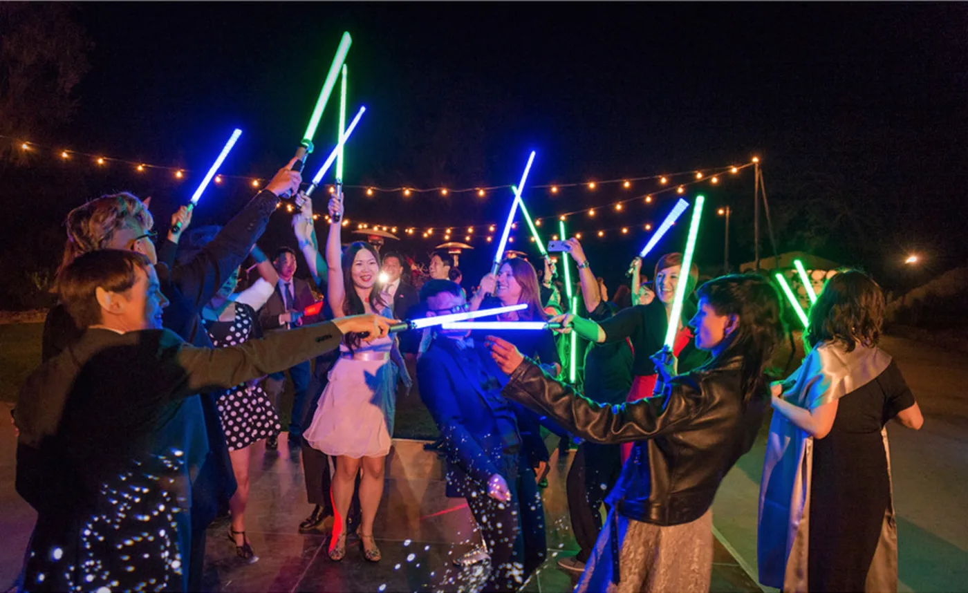 Guests waving glow sticks at a wedding send-off